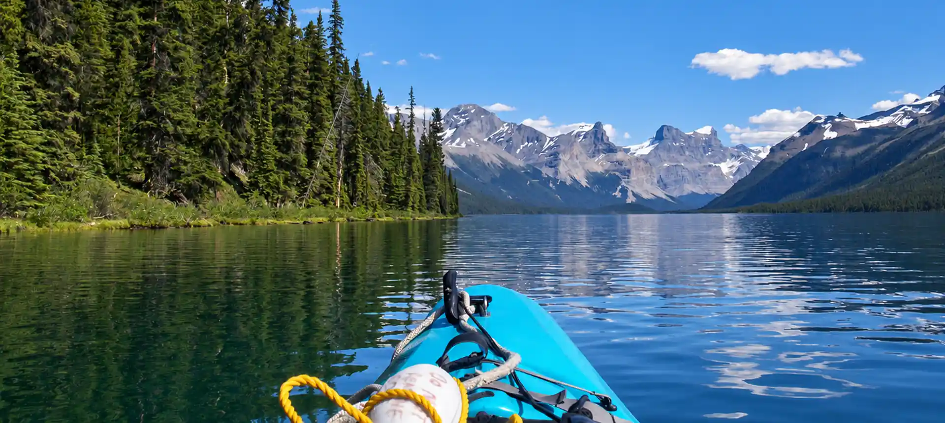 Kayak su un lago circondato da boschi e montagne